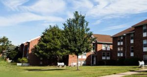 Exterior of Creekside Apartments with green grass and trees