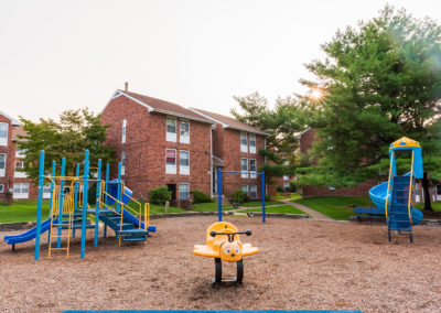 Outdoor playground with slides and bumble bee game outside Creekside residential buildings