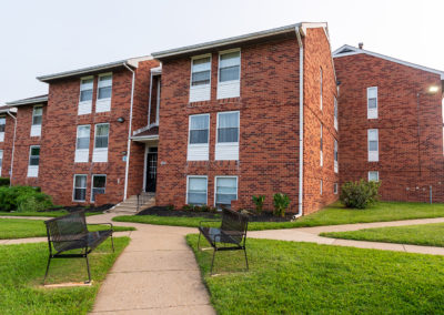 Exterior of Creekside Apartments in Bensalem with two benches