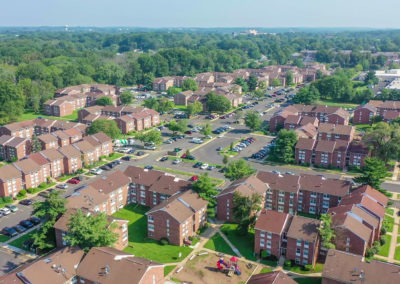 View of the beautiful Creekside Apartments complex in Bensalem, PA with brown buildings and vast parking spaces